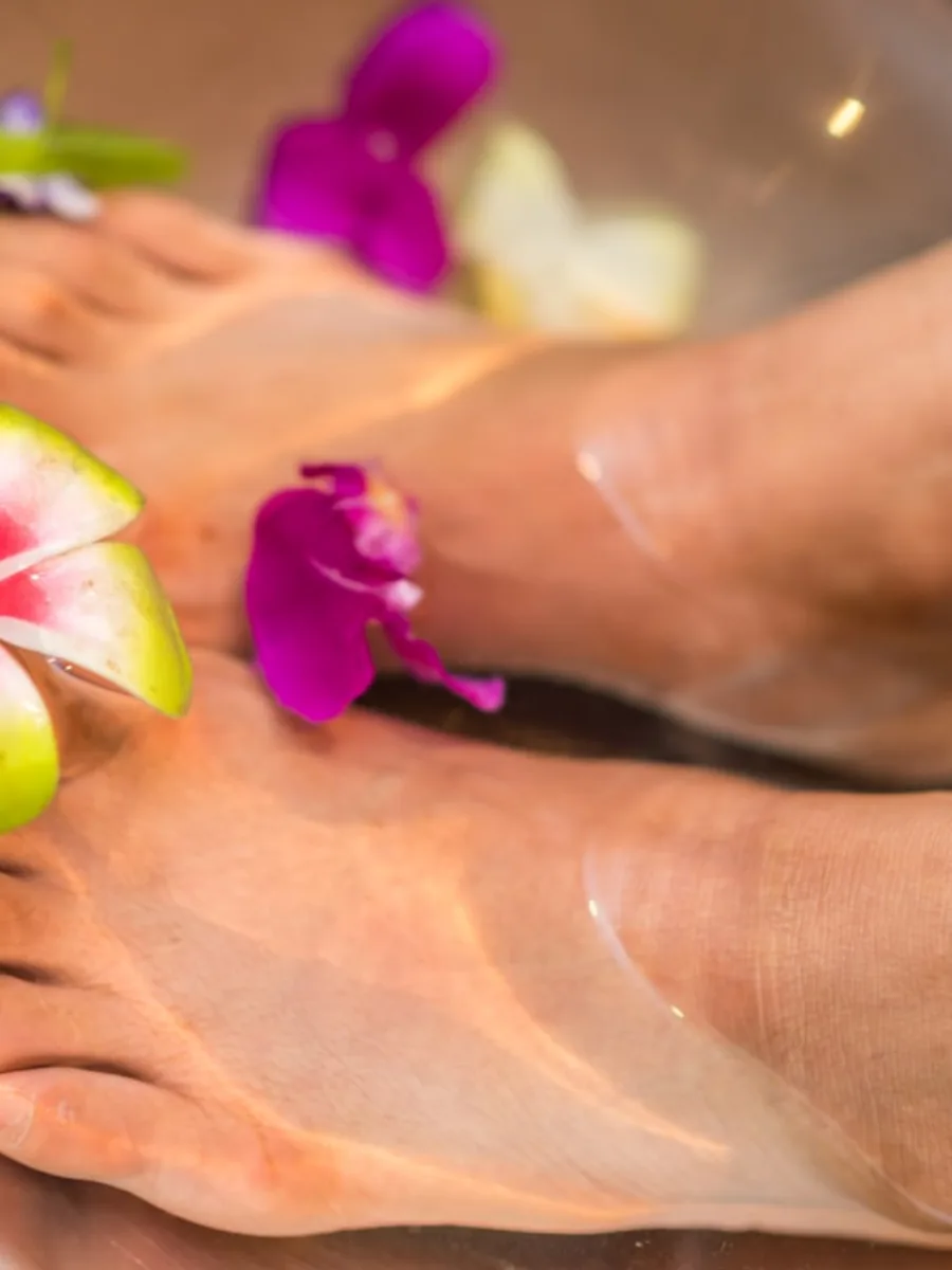 A pedicure soak with flowers on the water.